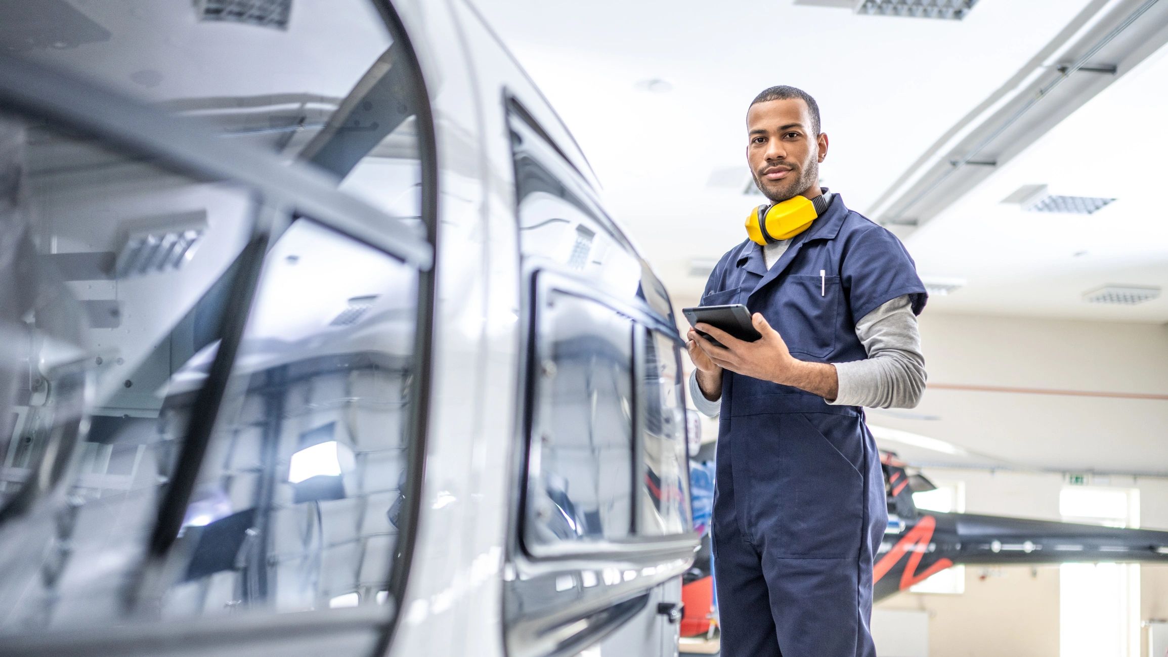 Technician standing near maintained mechanical equipment