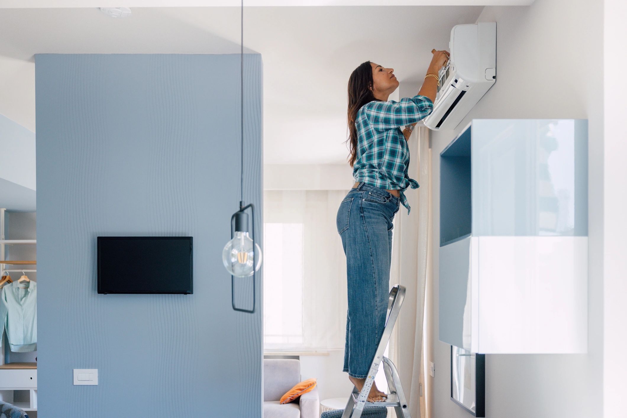 Technician servicing an indoor air conditioning unit